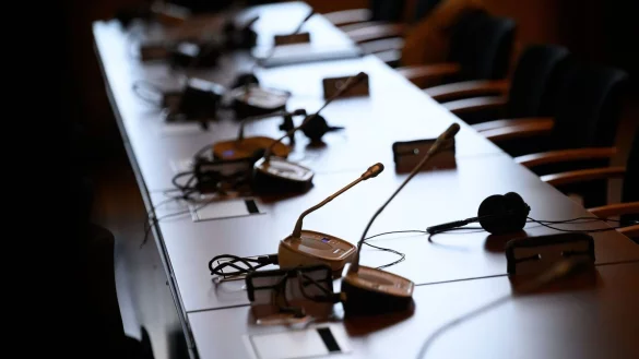 Mikrofone und Kopfh&ouml;rer auf einem Tisch in einem Gerichtssaal. - &copy; Jonas Walzberg/dpa/Symbolbild