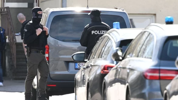 Einsatzkr&auml;fte stehen an Einsatzfahrzeugen. - &copy; Marijan Murat/dpa