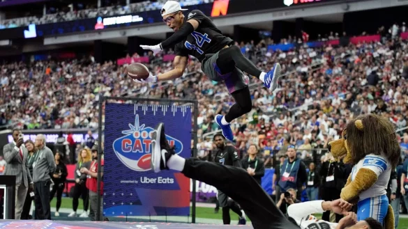 Detroits Wide Receiver Amon-Ra St. Brown (oben,l) f&auml;ngt beim NFL-Pro-Bowl spektakul&auml;r einen Ball. - &copy; John Locher/AP/dpa
