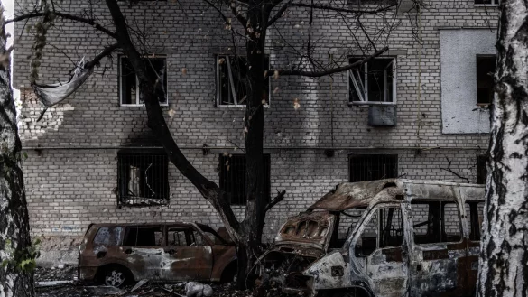 Augebrannte Autos vor einem schwer besch&auml;digten Wohnblock in der Frontstadt Orichiw. - &copy; Oliver Weiken/dpa