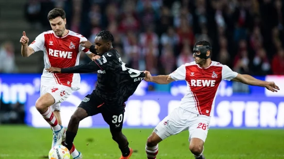 K&ouml;lns Jonas Hector (l) und Ellyes Skhiri (r) und Leverkusens Jeremie Frimpong versuchen an den Ball zu kommen. - &copy; Rolf Vennenbernd/dpa