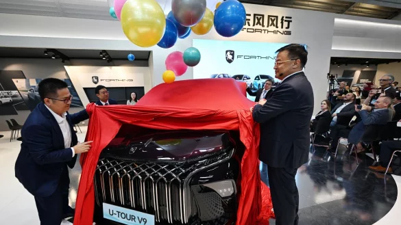 Manager der Dongfeng Liuzhou Motor Co. Ltd. enth&uuml;llen auf der IAA ein neues Fahrzeug der Marke Forthing. - &copy; Martin Schutt/dpa