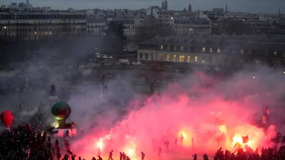 Demonstranten gehen am Ende der Demonstration gegen die geplante Heraufsetzung des Renteneintrittsalters in Paris durch Fackelrauch. - &copy; Thibault Camus/AP/dpa