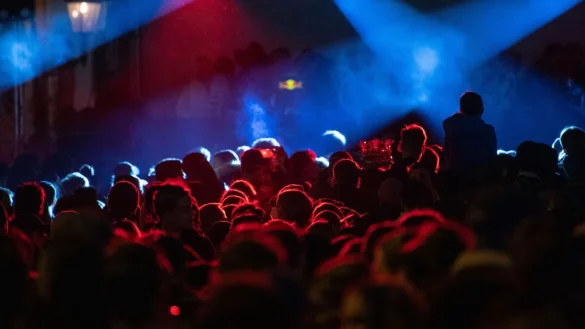 Menschen tanzen w&auml;hrend eines Konzerts. - &copy; Sebastian Gollnow/dpa/Symbolbild