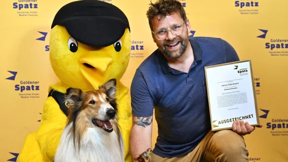 Der &laquo;Goldene Spatz&raquo;, Filmhund &laquo;Bandit&raquo; und Regisseur Hannes Olderdissen freuen sich &uuml;ber die Auszeichnung f&uuml;r &laquo;Lassie - Ein neues Abenteuer&raquo;. - &copy; Martin Schutt/dpa