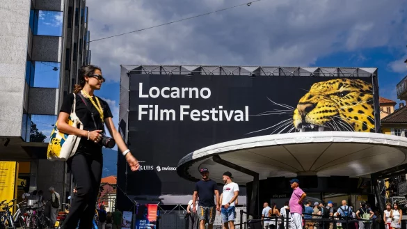 Eine Frau geht am Logo des Filmfestivals Locarno vorbei. - &copy; Jean-Christophe Bott/KEYSTONE/dpa
