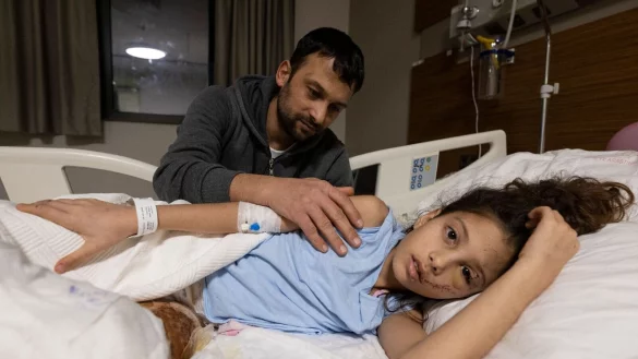 Z&auml;rtlich streicht Serkan Agri seiner Tochter Saadet im Krankenhaus von Adana &uuml;ber den Arm. - &copy; Boris Roessler/dpa