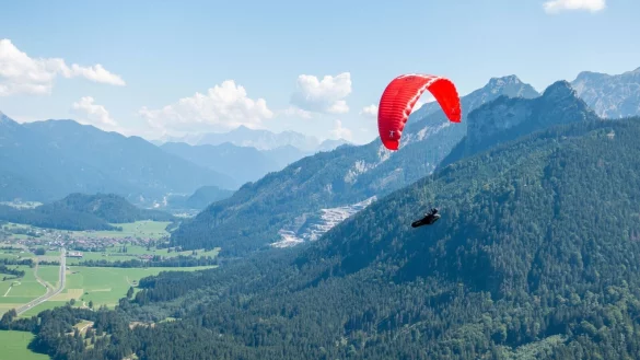 Verkehr am Himmel &uuml;ber Pfronten: Ein Solo-Paraglider fliegt neben dem Autoren und seinem Tandempiloten in Richtung Tal. - &copy; Andreas Drouve/dpa-tmn