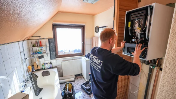 Ein Mitarbeiter einer Sanit&auml;r- und Heizungsbaufirma installiert eine moderne Gasbrennwerttherme in einem Einfamilienhaus. - &copy; Jan Woitas/dpa