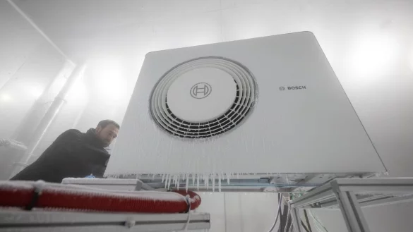 Ein Mitarbeiter der Bosch Thermotechnik GmbH &ouml;ffnet in einer Klimakammer das Geh&auml;use einer Bosch-W&auml;rmepumpe. - &copy; Marijan Murat/dpa