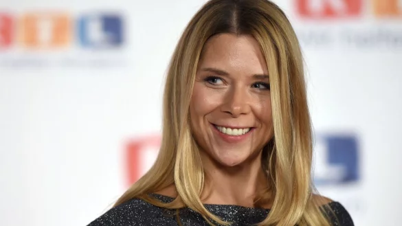 Die Schauspielerin Tanja Szewczenko lächelt beim RTL-Spendenmarathon vor einer Fotowand. - © Henning Kaiser/dpa/Archivbild