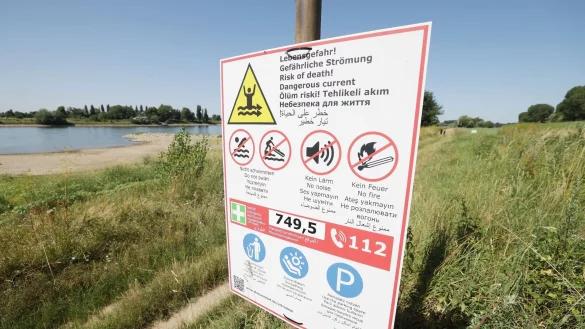 Ein Warnschild h&auml;ngt am Rhein. - &copy; David Young/dpa