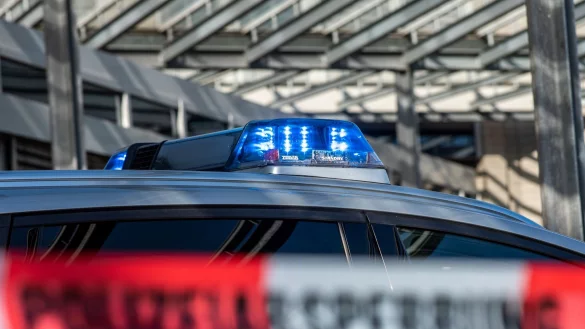 Ein Polizei-Blaulicht leuchtet &uuml;ber einem Absperrband mit der Aufschrift &laquo;Polizeiabsperrung&raquo;. - &copy; David Inderlied/dpa/Illustration