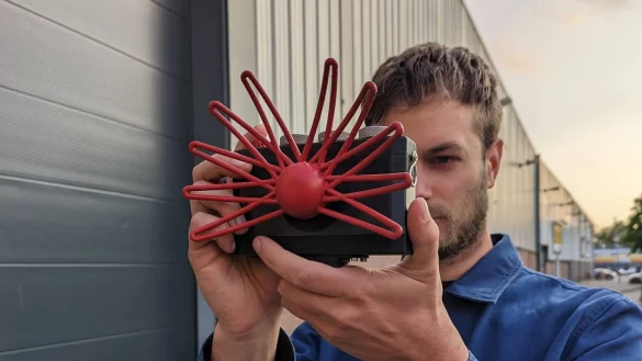 Eine stilisierte Maulwurfsnase statt eines Objektivs: Bj&oslash;rn Karmann mit der physischen Variante seiner Paragraphica, die mit Daten statt mit Licht &laquo;fotografiert&raquo;. - &copy; Bj&oslash;rn Karmann/dpa-tmn