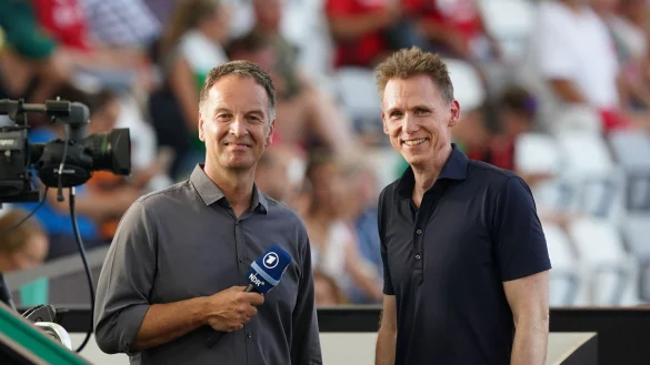 Der ehemalige Zehnkämpfer Frank Busemann (r) und ARD-Sportmoderator Claus Lufen stehen auf der Medientribüne. Für Busemann muss sich Leistung wieder lohnen. - © Marcus Brandt/dpa