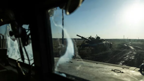 Ein zerstörter Panzer ist durch das Fenster eines Fahrzeugs an der Frontlinie in der Nähe von Klischtschijiwka bei Bachmut zu sehen. - © Alex Babenko/AP/dpa
