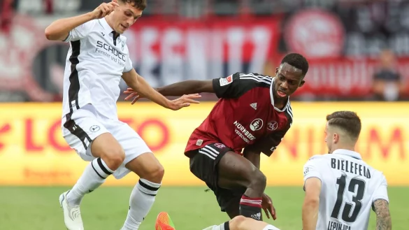 Der N&uuml;rnberger Sadik Fofana (M) k&auml;mpft mit Mateo Klimowicz (l) und Ivan Lepinjica von Bielefeld um den Ball. - &copy; Daniel Karmann/Deutsche Presse-Agentur GmbH/dpa/Archivbild