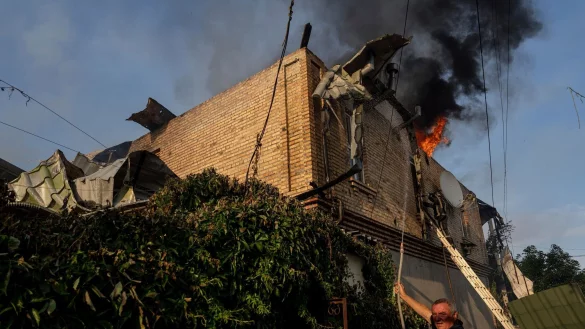 Ein Anwohner l&ouml;scht ein Feuer in einem Haus, das nach russischem Beschuss in Cherson, Ukraine, besch&auml;digt wurde. - &copy; Evgeniy Maloletka/AP/dpa