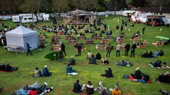 Zuschauer verfolgen auf einer Wiese das Open Air Konzert des Gitarristen John Scofield. - &copy; Bernd Thissen/dpa/Archivbild