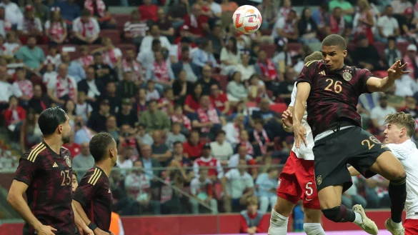 Deutschlands Malick Thiaw (r) kommt gegen Polens Jan Bednarek zum Kopfball. - &copy; Christian Charisius/dpa
