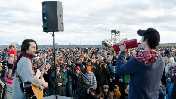 Christopher Annen (l) und Henning May (r) von der Band AnnenMayKantereit stehen in L&uuml;tzerath auf einer B&uuml;hne am Rand des Tagebaus. - &copy; Henning Kaiser/dpa/Archivbild