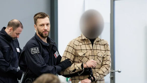 Ein Angeklagter (r) wird von Justizbeamten in Handschellen in den Gerichtssaal des Oberlandesgerichts Dresden gef&uuml;hrt. - &copy; Jens Schlueter/POOL AFP/dpa