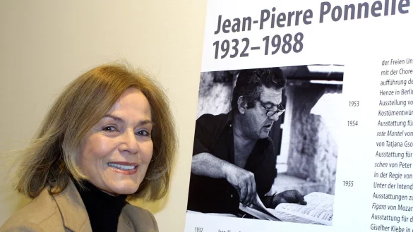 Margit Saad neben einem Bild ihres Mannes Jean-Pierre Ponnelle. - &copy; Tom Maelsa/dpa