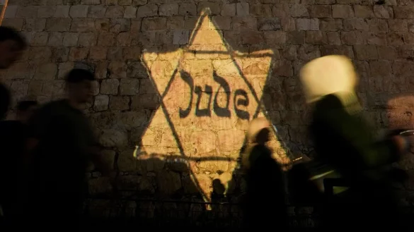 Ein gelber Davidstern mit der Aufschrift &laquo;Jude&raquo;, &auml;hnlich dem, den Juden in Nazi-Deutschland tragen mussten, wird am Abend des j&auml;hrlichen Holocaust-Gedenktages Yom HaShoah auf die Mauern der Jerusalemer Altstadt projiziert. - &copy; Mahmoud Illean/AP/dpa