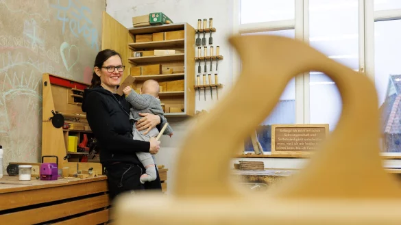 Johanna R&ouml;h steht mit ihrem Kind auf dem Arm in der Werkstatt ihres Betriebes. Die Mutter und Tischlermeisterin hat eine Petition zur Reform des Mutterschutzes auf den Weg gebracht. - &copy; Friso Gentsch/dpa