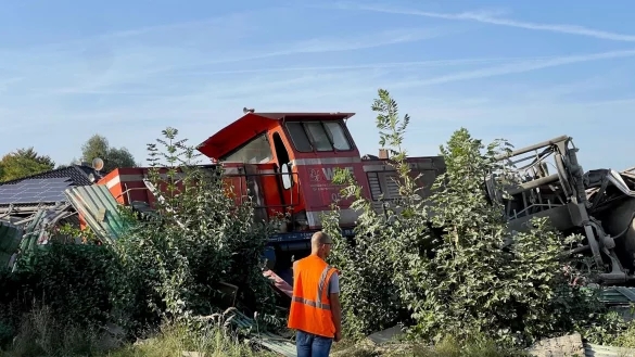Teile eines entgleisten Güterzuges sind hinter Sträuchern zu sehen. - © Christian Müller/Westfalennews/dpa