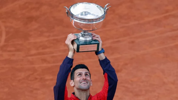 French-Open-Sieger Novak Djokovic reckt die Troph&auml;e in die H&ouml;he. - &copy; Jean-Francois Badias/AP/dpa