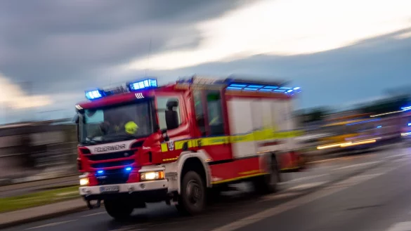 Ein L&ouml;schfahrzeug der Feuerwehr f&auml;hrt mit Blaulicht zu einem Einsatz. - &copy; Lino Mirgeler/dpa/Symbolbild