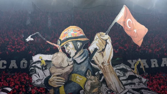 Beim Fußballspiel der Teams Trabzonspor gegen den FC Basel, im Senol Gunes Stadion, zeigen Fans ein Bild zu Ehren der Erdbebenopfer in der Türkei und Syrien. - © Uncredited/AP/dpa