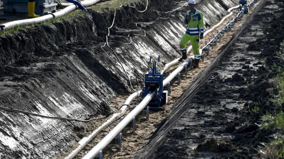 Ein Bauarbeiter &uuml;berwacht das Einziehen von einem Gleichstrom-Erdkabel. - &copy; Carsten Rehder/dpa/Symbolbild
