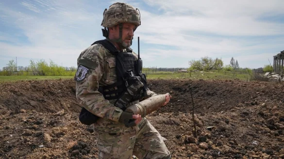 Ein ukrainischer Soldat sammelt nicht explodierte Granaten ein. - &copy; Andrii Marienko/AP/dpa