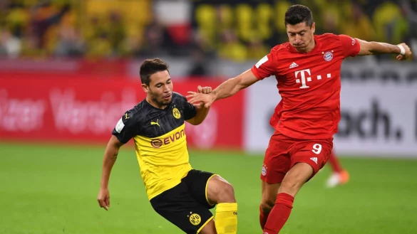 Dortmunds Raphael Guerreiro (l) und Bayerns Robert Lewandowski k&auml;mpfen um den Ball. - &copy; Marius Becker/dpa/Archivbild