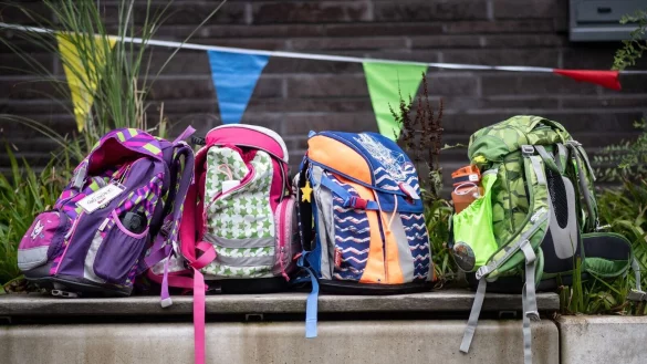 Vier Schulranzen stehen bei einer Einschulung in einer Grundschule auf einer Bank. - © Bernd Thissen/dpa/Symbolbild