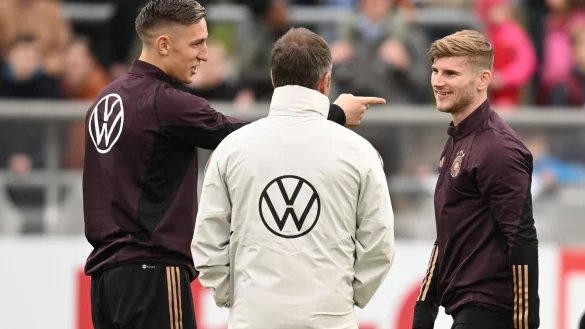 Timo Werner (r), Nico Schlotterbeck (l) und Bundestrainer Hansi Flick sprechen w&auml;hrend einer Trainigseinheit miteinander. - &copy; Arne Dedert/dpa
