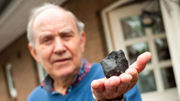 Wilfried Labusch in Elmshorn mit dem kleinen Meteoriten, der in sein Haus niedergegangen ist. - © Daniel Bockwoldt/dpa/Daniel Bockwoldt