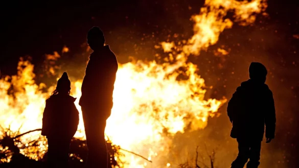Ein Mann und zwei Kinder stehen vor einem Osterfeuer. - &copy; picture alliance/Nicolas Armer/dpa/Symbolbild