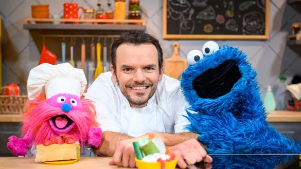 Fernsehkoch Steffen Henssler zwischen den Puppen &laquo;Gonger&raquo; (l) und &laquo;Kr&uuml;melmonster&raquo; am Film-Set. - &copy; Jonas Walzberg/dpa