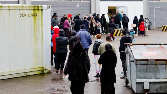 Menschen stehen bei einer Essenausgabe in der Landesunterkunft der Gemeinde Seeth im Kreis Nordfriesland Schlange. - &copy; Frank Molter/dpa