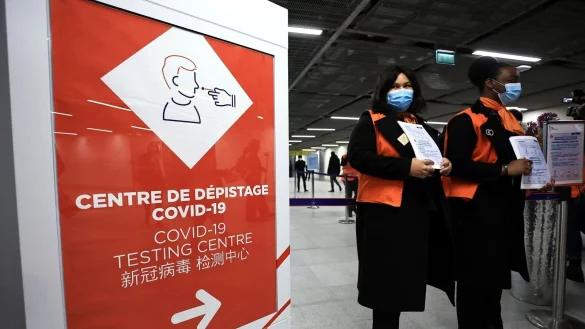 Zwei Flughafenmitarbeiterinnen warten auf dem franz&ouml;sischen Flughafen Roissy-Charles de Gaulle auf Passagiere aus China. - &copy; Aurelien Morissard/AP/dpa