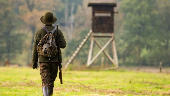 Eine J&auml;gerin geht mit ihrer Bockb&uuml;chsflinte zu einem Hochsitz. - &copy; Philipp Schulze/dpa
