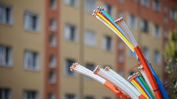Aus dem Sockel eines Schaltschranks ragen Glasfaserkabel heraus. Beim Breitbandausbau sieht die Lage inzwischen deutlich besser aus als noch vor zwei Jahren. - &copy; Jan Woitas/dpa
