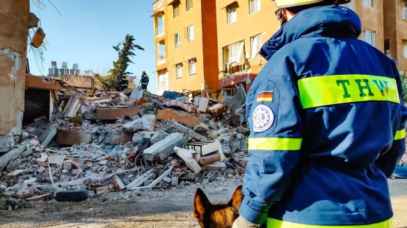 Ein Helfer der Schnell-Einsatz-Einheit Bergung Ausland (SEEBA) des THW steht neben seinem Hund der türkischen Provinz Hatay. - © -/THW/dpa