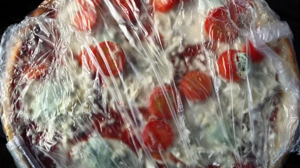 Eine in Plastikfolie gepackte tiefgek&uuml;hlte Fertigpizza. Die Nachfrage nach Tiefk&uuml;hlkost hat einen Rekord erreicht. - &copy; picture alliance / dpa