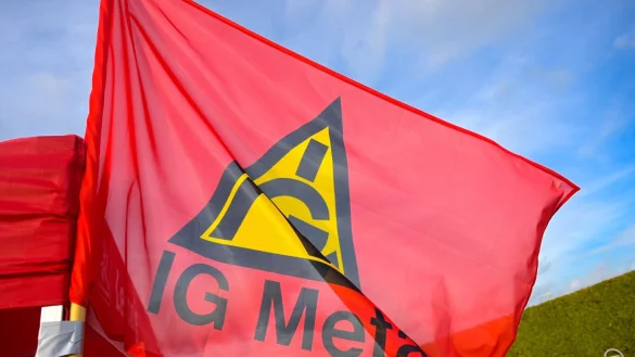 Fahne mit Logo der IG Metall an einem Stand. - © Heiko Rebsch/dpa/Symbolbild