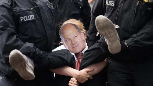 Polizisten tragen während eines Protestmarsches der Klimaschutzgruppe Letzte Generation eine Teilnehmerin von der Straße. - © Sebastian Christoph Gollnow/dpa