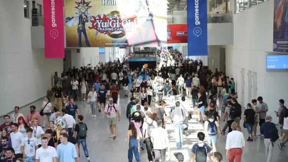 Besucher der Spielemesse Gamescom laufen durch eine der Mesehallen. - © Sascha Thelen/dpa